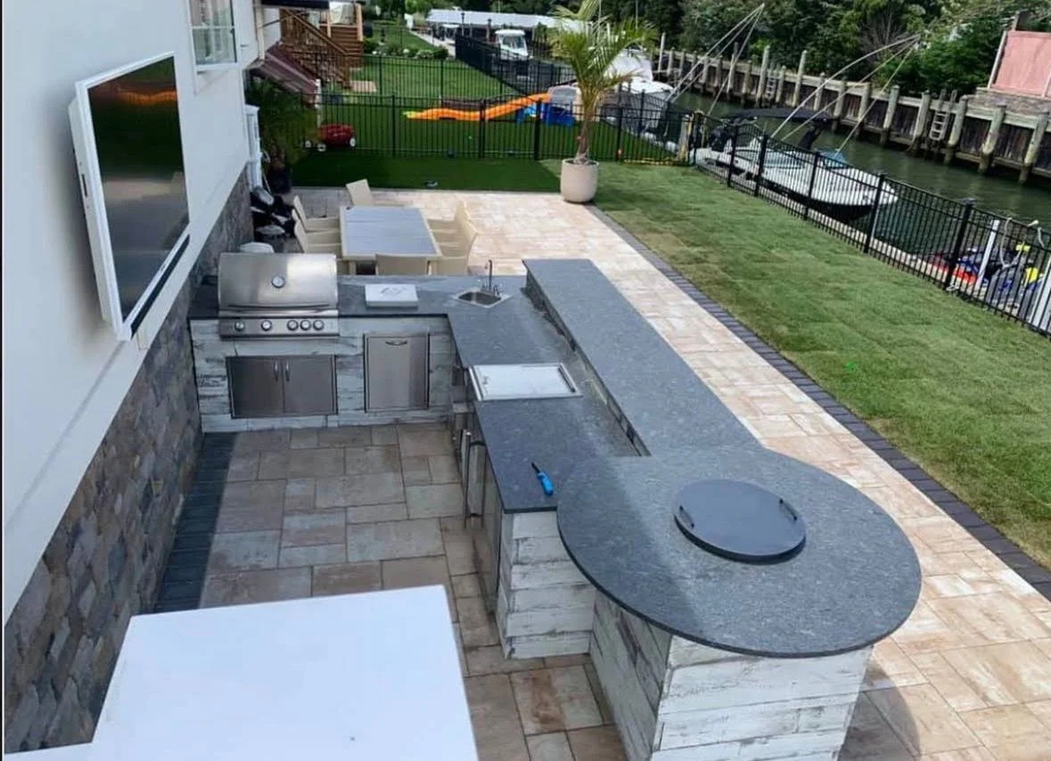 Waterfront outdoor kitchen with stone veneer and paver patio